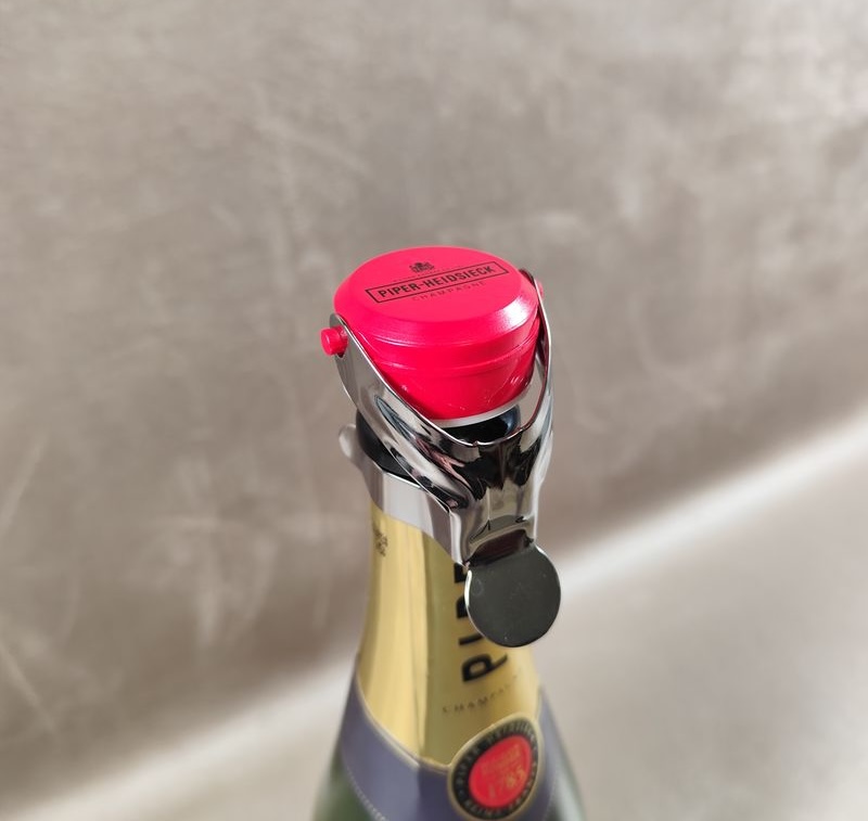 Bouchon stoppeur personnalisé au logo d'une Maison de champagne posé sur une bouteille